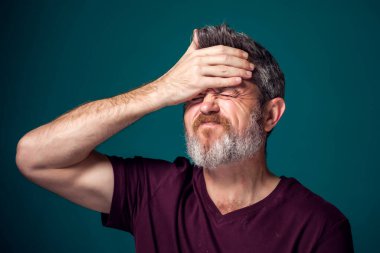 Kırmızı tişörtlü üzgün sakallı adamın portresi. İnsanlar ve duygular