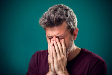 Kırmızı tişörtlü üzgün sakallı adamın portresi. İnsanlar ve duygular