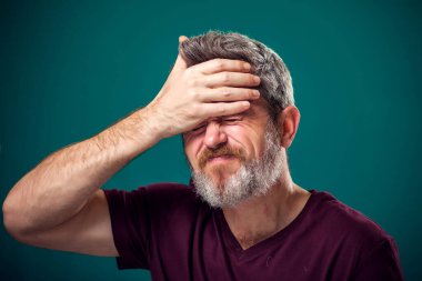 Kırmızı tişörtlü üzgün sakallı adamın portresi. İnsanlar ve duygular