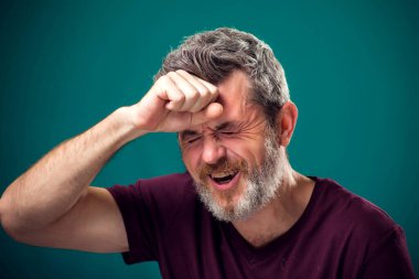 Kırmızı tişörtlü üzgün sakallı adamın portresi. İnsanlar ve duygular