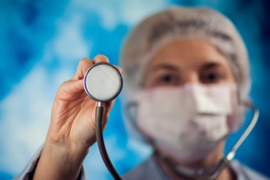 Elinde fonendoskop tutan mavi eldivenli kadın doktor. Halk, tıp ve sağlık hizmetleri kavramı