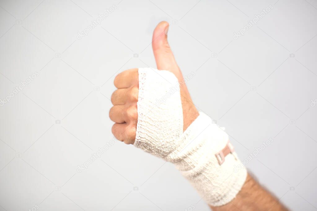 Elastic bandage on hand. Thumb up gesture. Healthcare and medicine concept