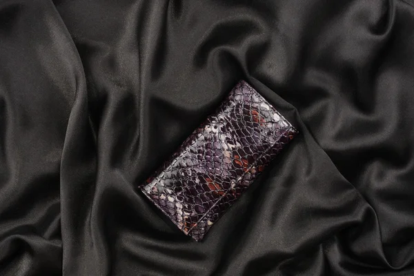 Purse lacquer on a black silk — Stock Photo, Image