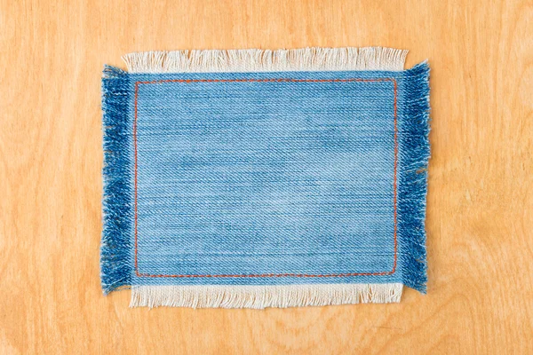 Cadre pour le texte d'un tissu en jean bleu avec les lignes cousues d'un fil orange et frangé — Photo