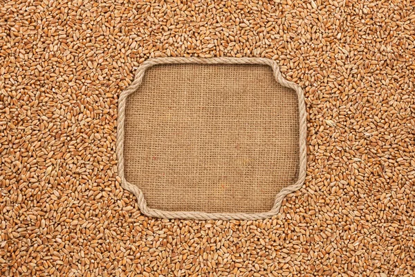 Figured frame made of rope with wheat grains on sackcloth — Stock Photo, Image