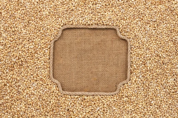Figured frame made of rope with pearl barley  on sackcloth — Zdjęcie stockowe