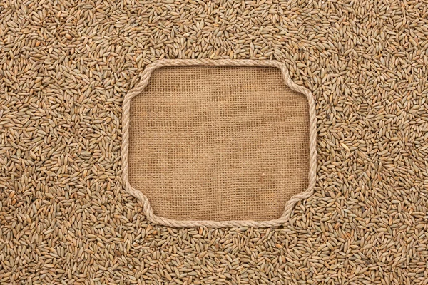 Figured frame made of rope with rye grains on sackcloth — Stock Photo, Image