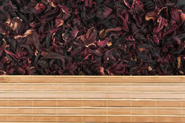 Fiori secchi di ibisco e tappetino di bambù — Foto Stock