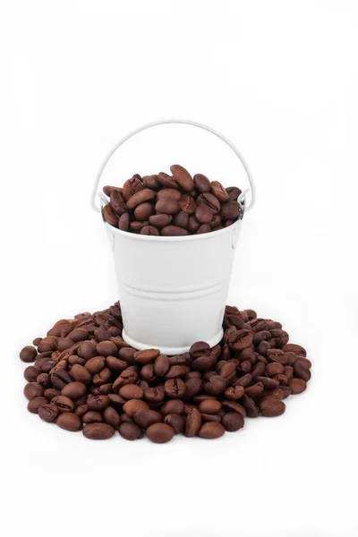 White bucket full of coffee beans, stands on a heap coffee beans — Stock Photo, Image