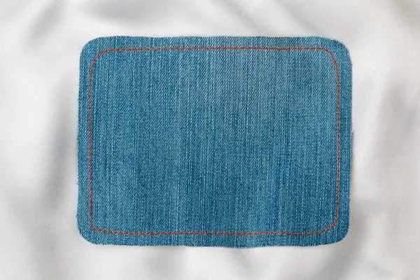 Frame made of denim fabric with yellow stitch on white silk  with space for your text — ストック写真