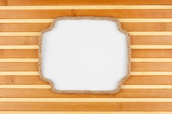 Frame of rope lying on a bamboo mat with a white background  for your text — Stock Photo, Image