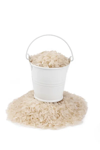 Balde branco cheio de arroz, fica em um amontoado de arroz, em um backgr branco — Fotografia de Stock