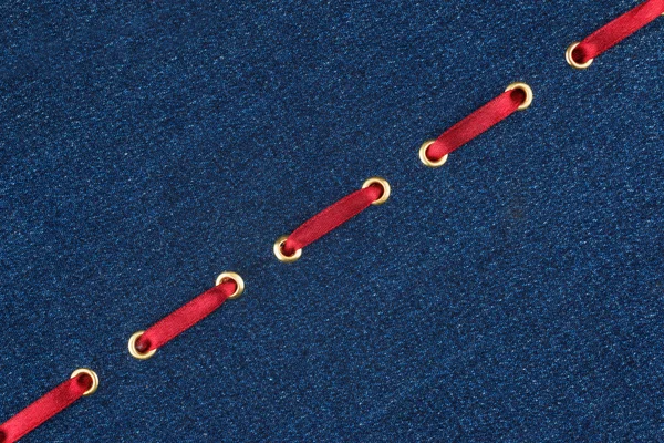 Модний фон червона атласна стрічка вставлена в денімі — стокове фото
