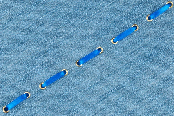 Fashionable background, blue satin ribbon inserted in denim — Stock Photo, Image