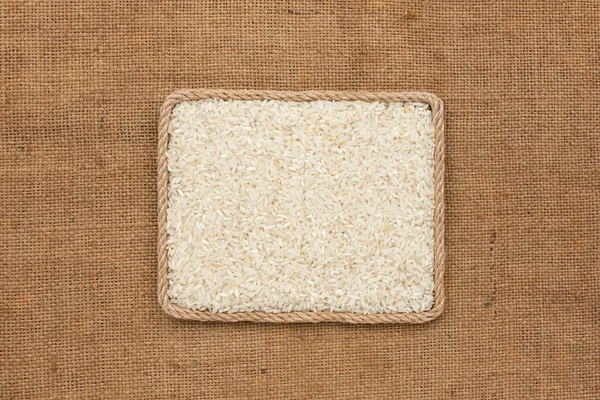 Frame made of rope with rice grains on sackcloth, view from above — Stock Photo, Image