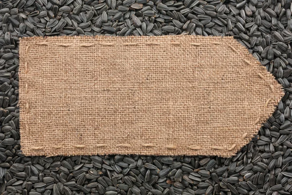 Pointer of burlap lying on a sunflower seeds background — Stock Photo, Image
