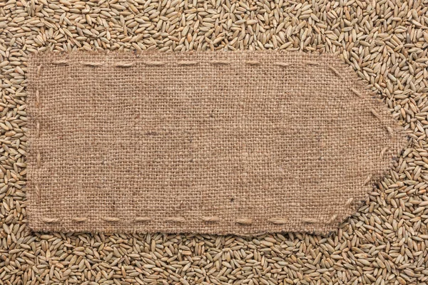 Pointer of burlap lying on a rye background — Stock Photo, Image