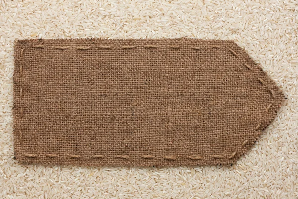 Pointer of burlap lying on a rice background — Stock Photo, Image