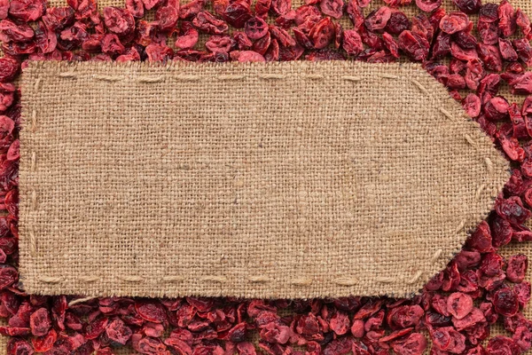 Pointer of burlap lying on a dry cranberry background — Stock Photo, Image