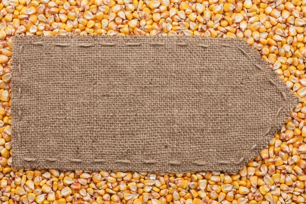 麻布躺在玉米背景上的指针 — 图库照片