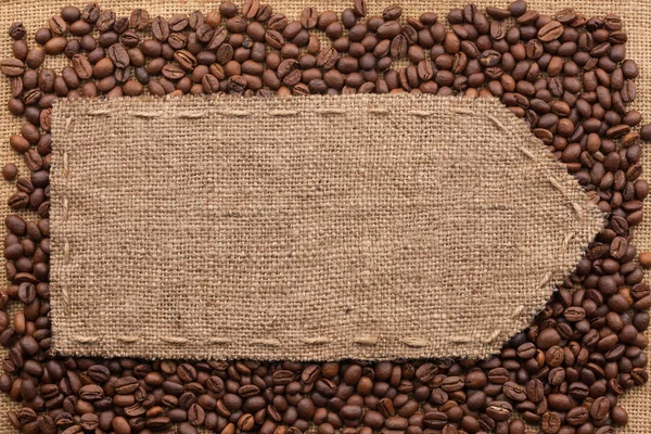 Ponteiro de serapilheira deitado sobre um fundo de grãos de café — Fotografia de Stock