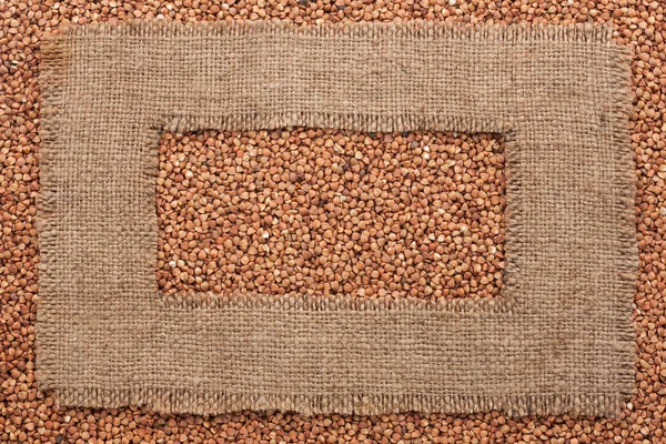 Cadre en toile de jute rugueuse repose sur les grains de sarrasin — Photo