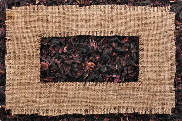 Ram av grov säckväv ligger på torkade hibiscus — Stockfoto