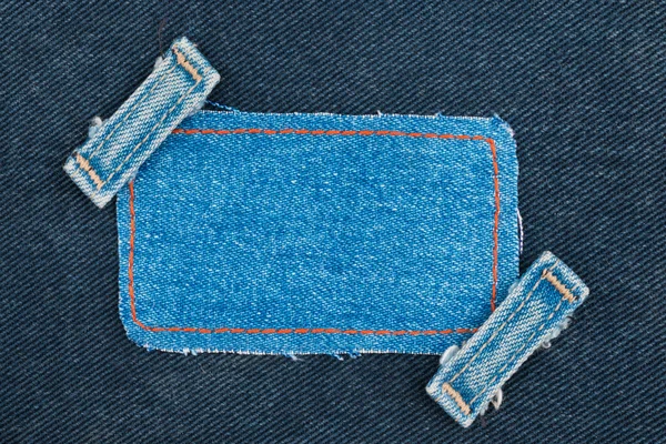 Marco, etiqueta, precio con dos correas jeans, se encuentra en el denim oscuro —  Fotos de Stock