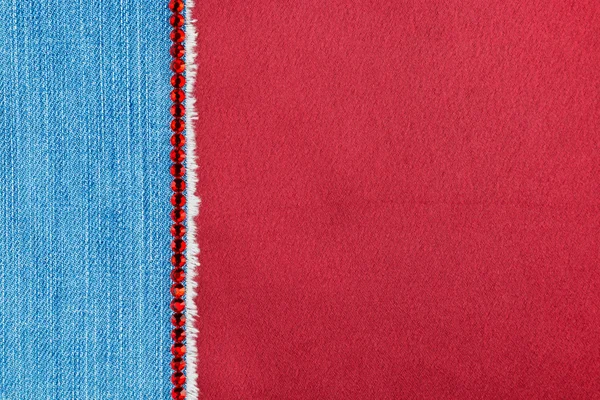 Denim decorado com strass vermelho deitado em cetim — Fotografia de Stock