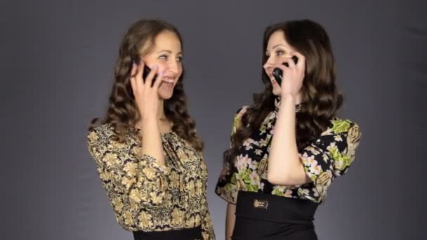 Two beautiful girls talking on the phone — Stock Video