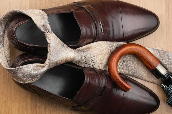 Men's classic accessories: brown shoes, tie, umbrella on a wooden surface — Stock Photo, Image