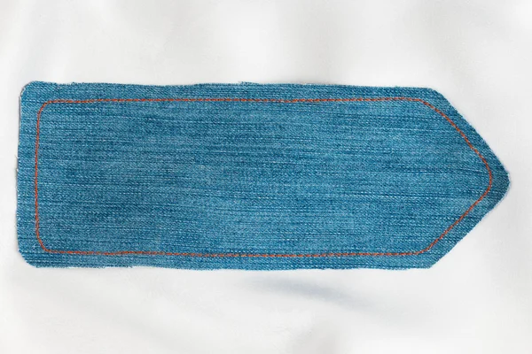 Pointer made of denim fabric with yellow stitching on white silk — Stock Photo, Image