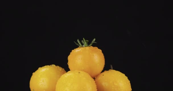 Gotas de lluvia cayendo sobre una pila giratoria de tomate amarillo. — Vídeo de stock