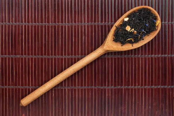 Wooden spoon with black tea — Stock Photo, Image