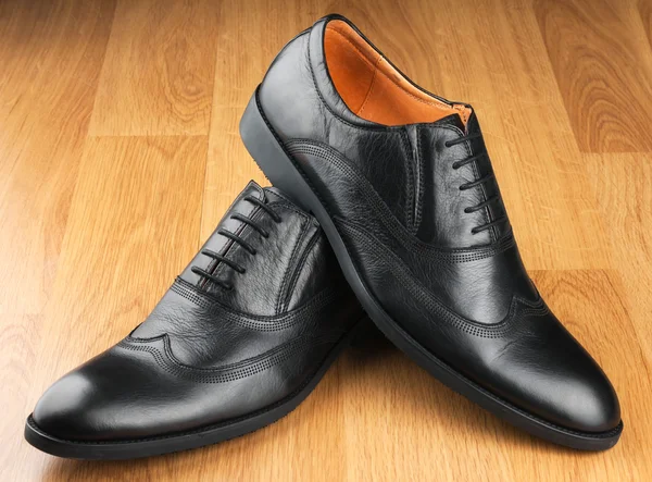 Classic men's shoes stand on the wooden floor — Stock Photo, Image