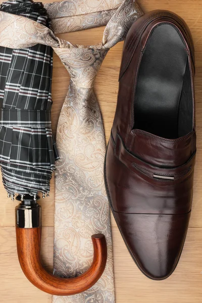 Zapatos clásicos para hombre, corbata, paraguas en el suelo de madera —  Fotos de Stock