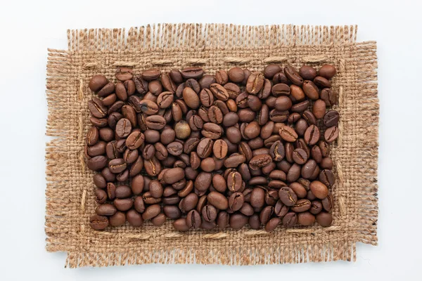 Frame of burlap and coffee beans lying on a white background — Stock Photo, Image