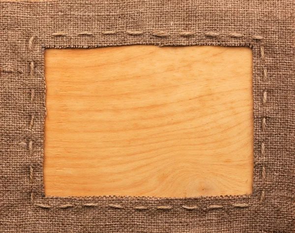 Marco de arpillera, se encuentra sobre un fondo de madera — Foto de Stock