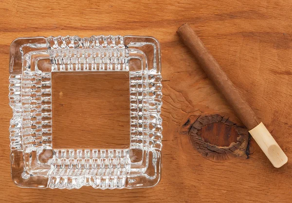 Glass ashtray with cigar  on a wooden surface — Stok fotoğraf