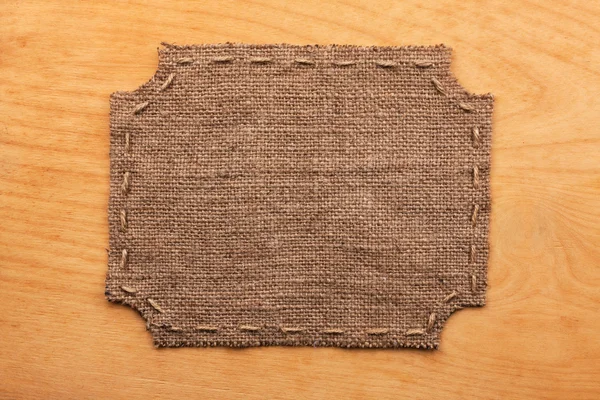 Frame of burlap, lies on a background of wood — Zdjęcie stockowe