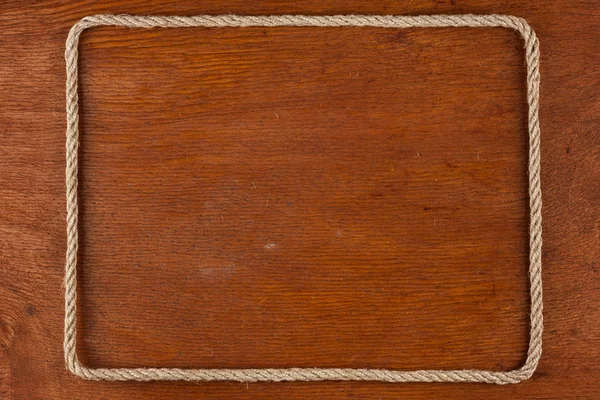 Frame of rope, lies on a background of a wooden surface — Stock Photo, Image