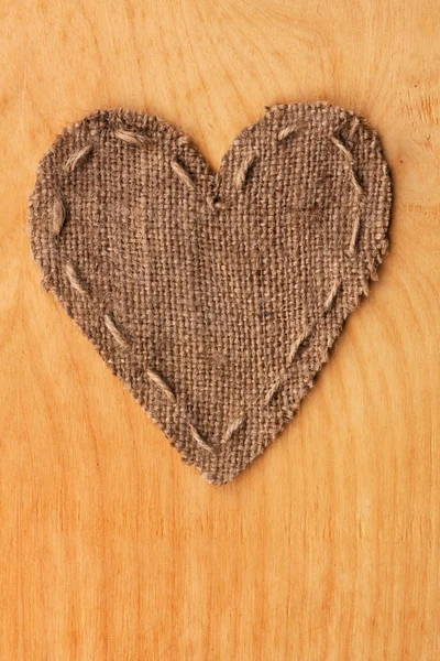 Coração de serapilheira, encontra-se sobre um fundo de madeira — Fotografia de Stock