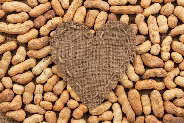 Heart of  burlap, lies on a background of peanut — Stock Photo, Image