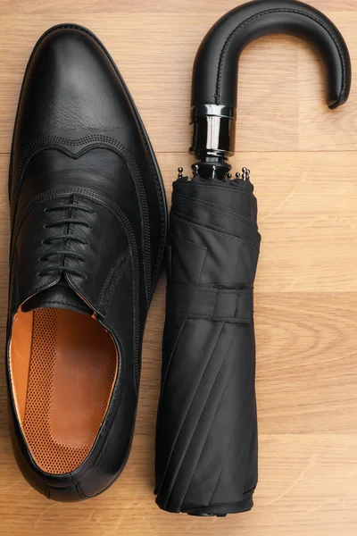 Zapatos clásicos para hombre y paraguas en el suelo de madera — Foto de Stock