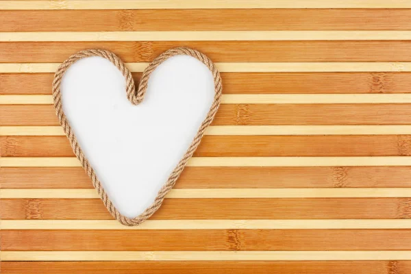 Symboliczne serca wykonane z lin leżącego na mat bambusowych — Zdjęcie stockowe