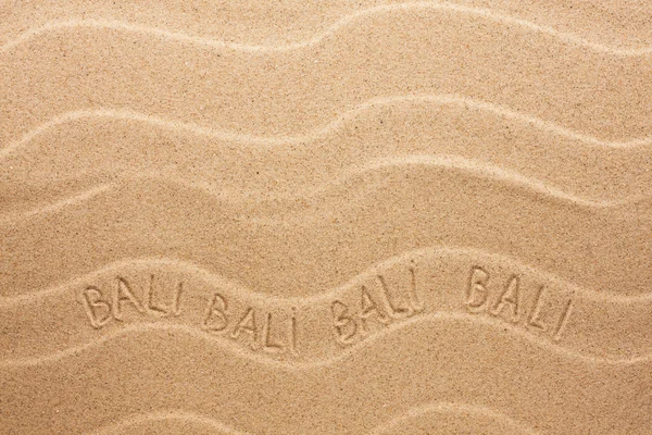 Bali inscriptie op de golvende zand — Stockfoto
