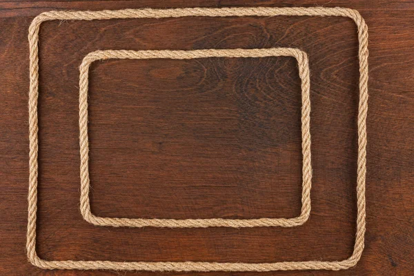 Frame of rope, lies on a background of a wooden surface