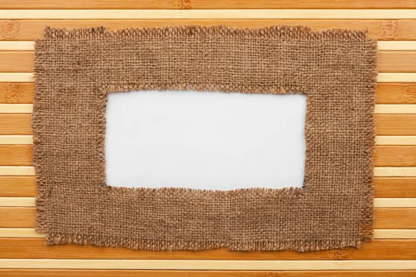 Stomme av säckväv med vit bakgrund ligga på en bambu matta — Stockfoto