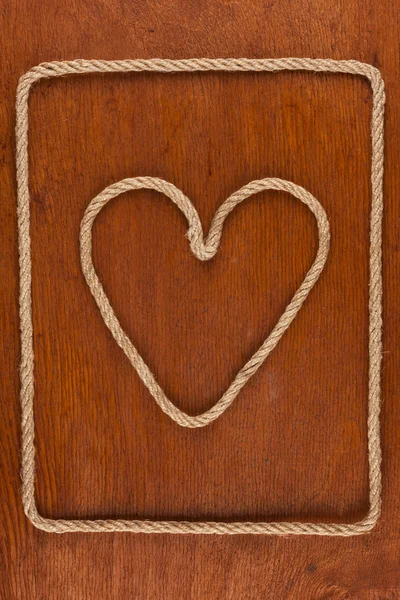 Coeur en corde sur une surface en bois — Photo