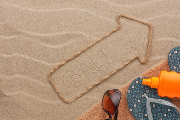 Bali pointer and beach accessories lying on the sand — Stock Photo, Image